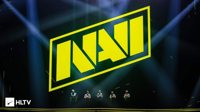 The logo for Natus Vincere appears writ large on the screen of the stage, with the team's roster standing beneath it lit up by the stage lights