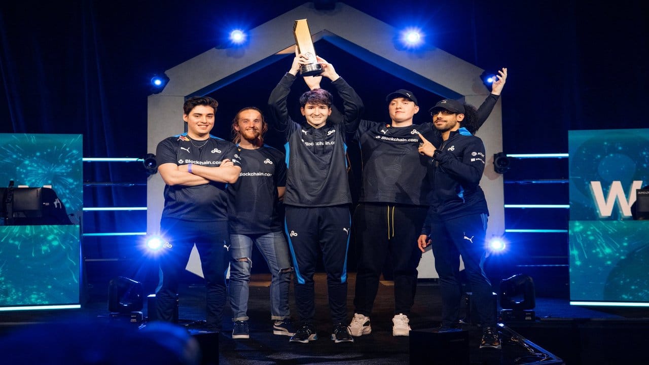 The roster for Cloud9 stand on stage holding the HCS Anaheim trophy above their heads after winning the Grand Finals