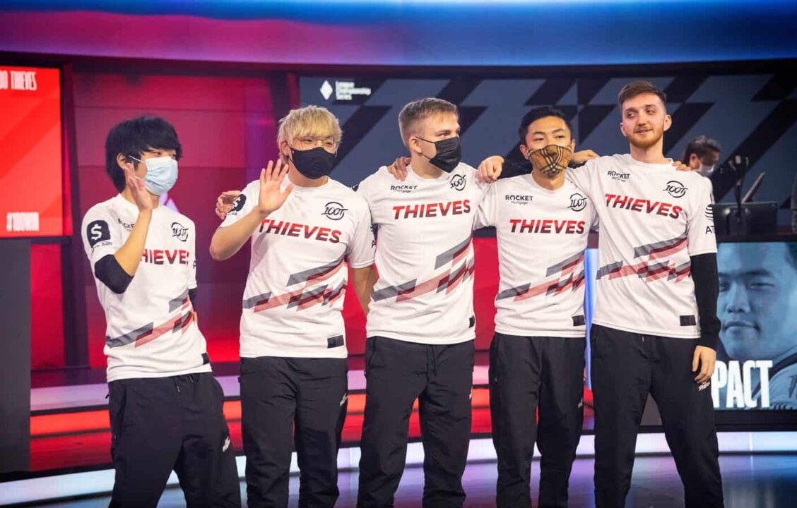 The 100 Thieves LoL roster of Ssumday, Huhi, Abbedagge, FBI and Closer pose together on the LCS stage.