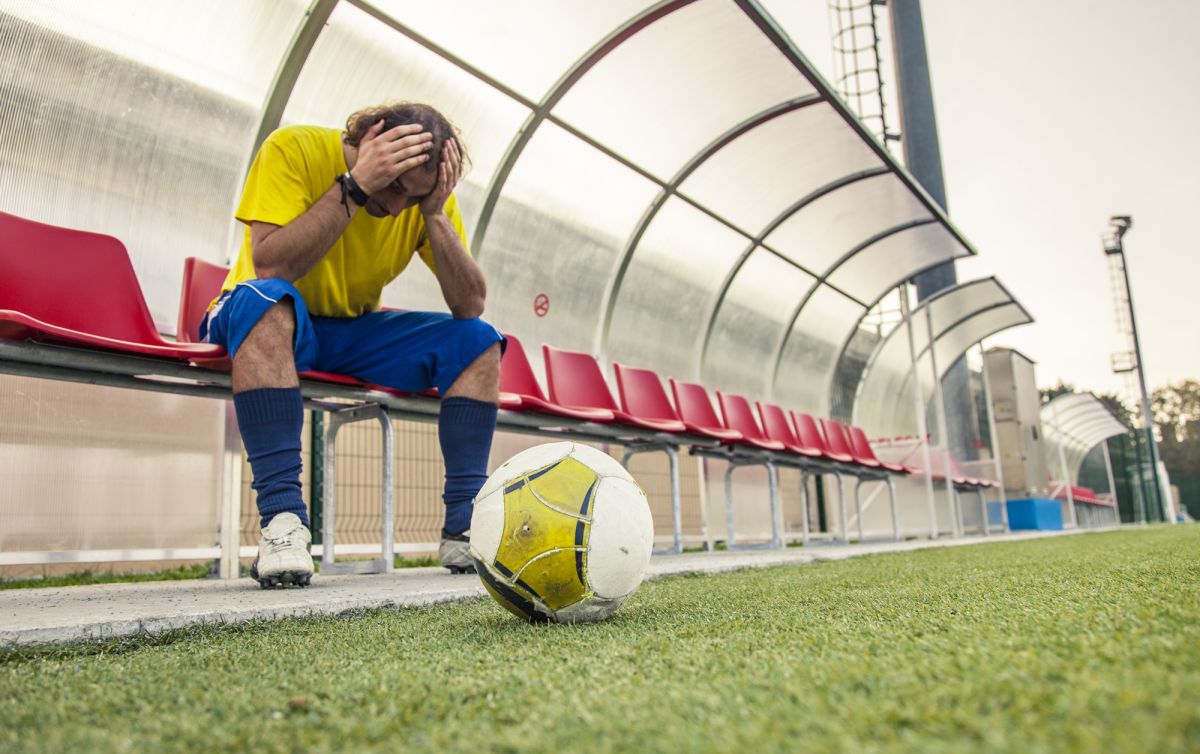 A footballer holds their head in their hands after hearing about eFootball