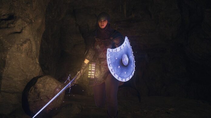 A warrior Arisen walking through a dark cave in Dragon