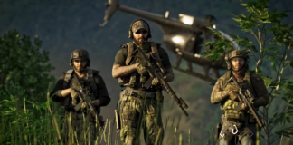 Three soldiers in camo holding guns and walking through long grass